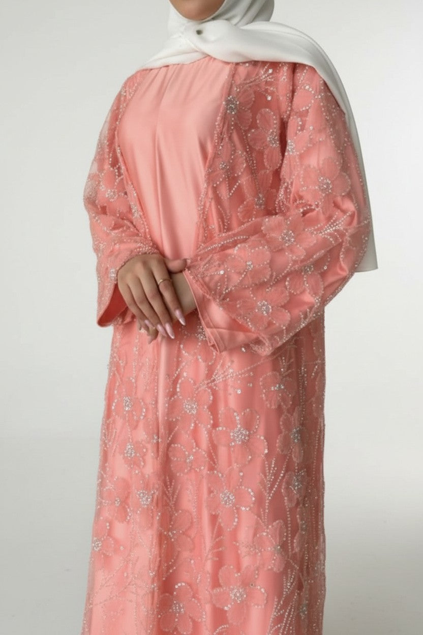 Peach-colored dress with floral embroidery on a plain background