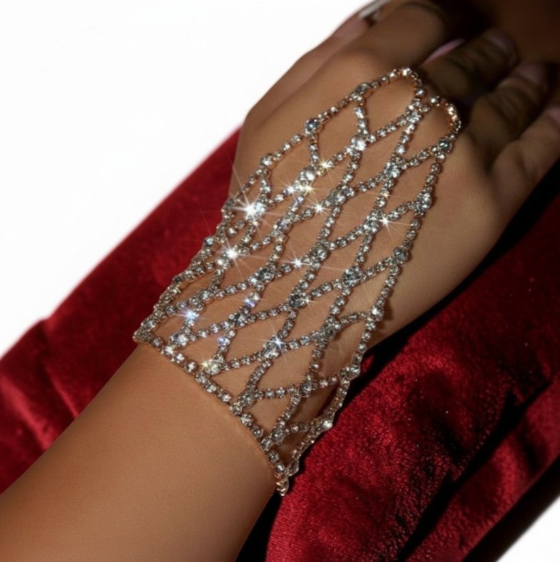Silver arm chain with crystals on a person's arm against a red fabric background