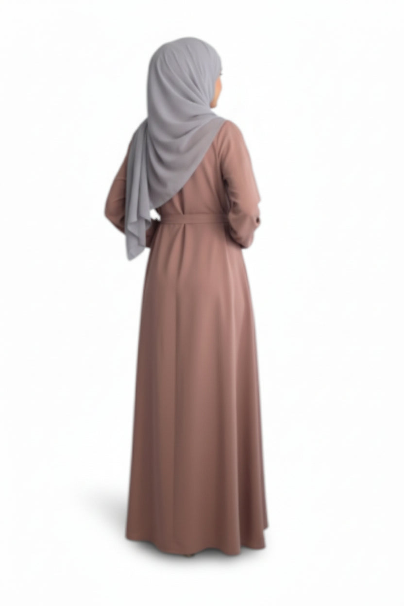 Woman wearing a long pink dress and gray hijab on a white background